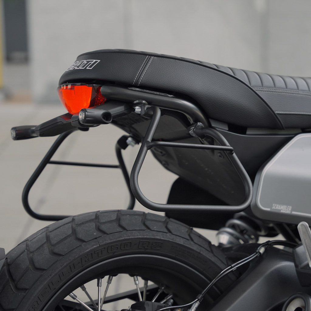 Ducati Scrambler avec supports pour sacoches souples latérales.